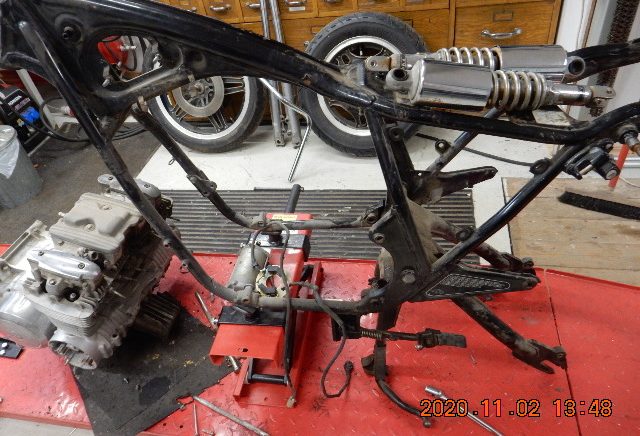 Demonterad Honda CB650. Motorcykelram med motor och delar på ett verkstadsbord.